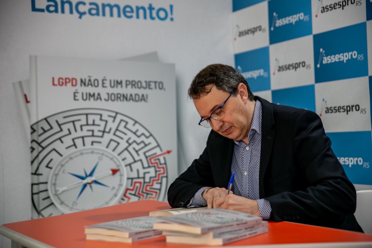 Reges Bronzatti autografando exemplares no lançamento